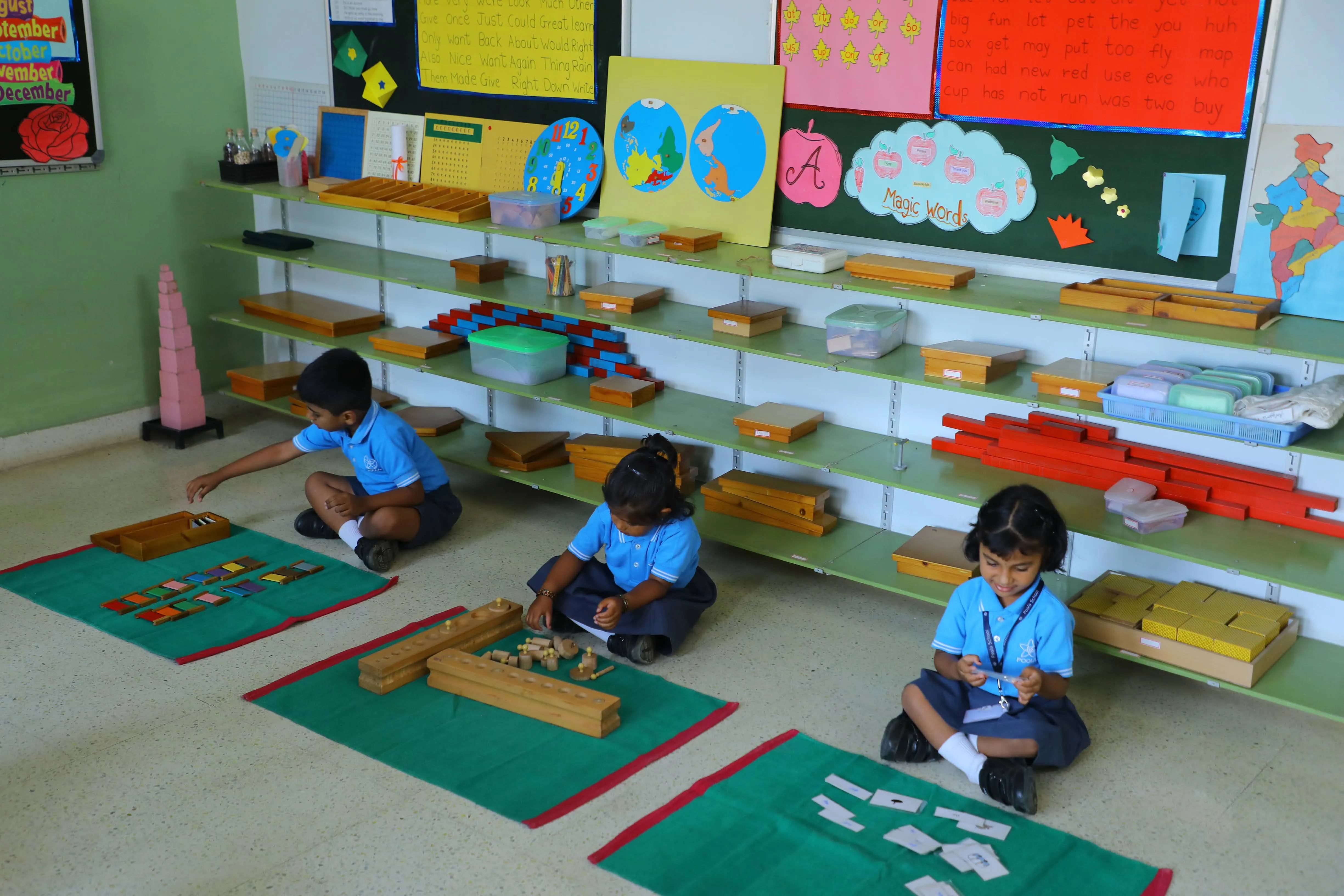 Young children working independently with Montessori materials on floor mats